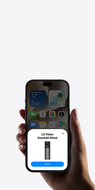 Une main tient un iPhone qui affiche l’app Domicile et une invite de configuration pour un accessoire domotique