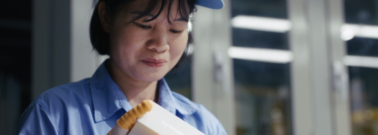 Une personne dans un centre de logistique et de réparation souriant à la caméra