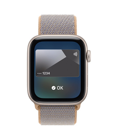 Apple Watch SE 3, aluminiumboett i färgen stjärnglans, på skärmen visas Plånbok och grafik med betalningskort, höger utsida, Digital Crown, sportloop i färgen chambrayblå (ljust blågrå)