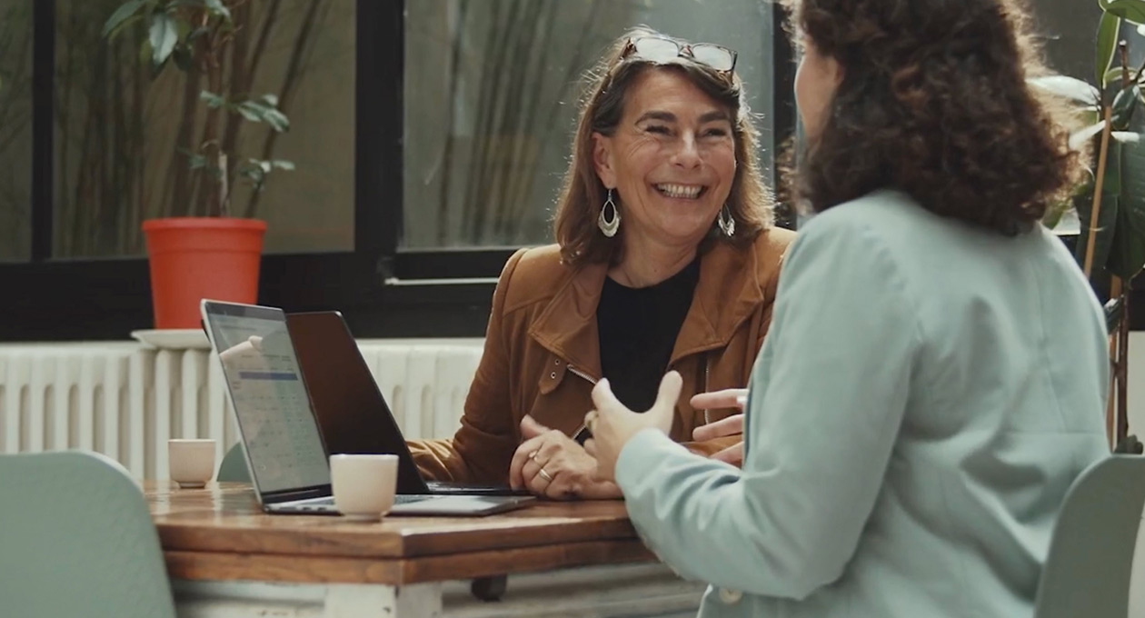 Vrouwen die in een café aan MacBooks werken