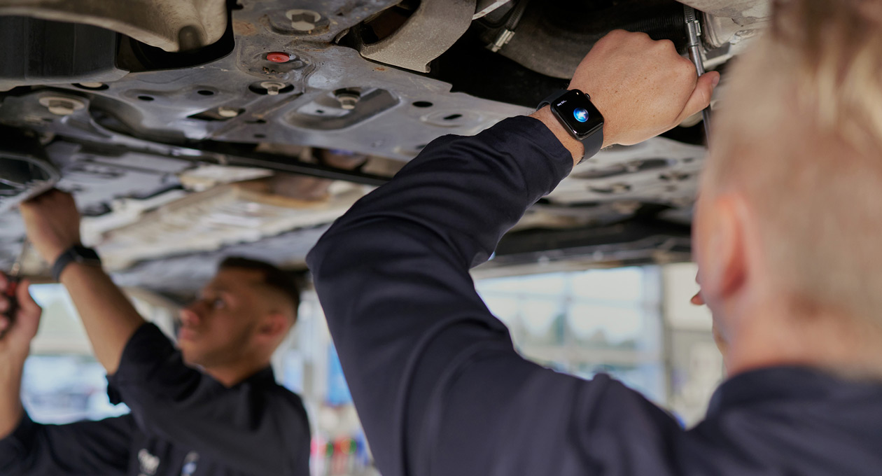 Tekniker som använder Apple Watch medan de utför service på en bil
