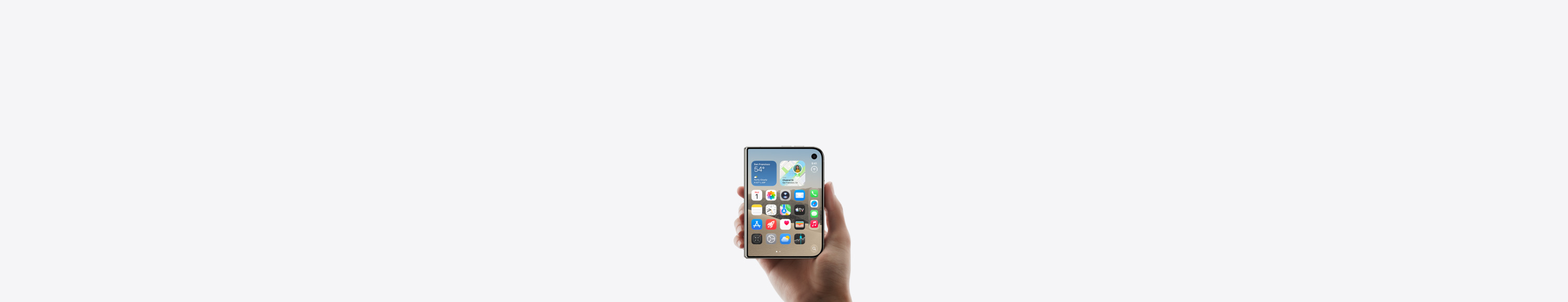 iPhone Duo, Star White color, held by a hand in closed position, outer display shown, iOS home screen with apps and widgets.