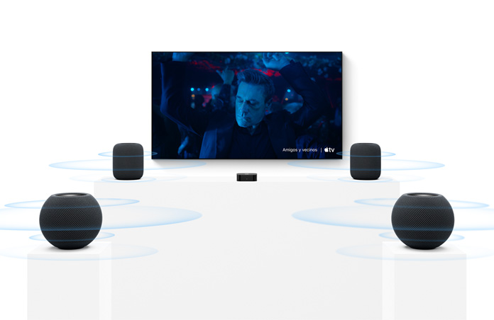 Apple TV 4K, pantalla de TV, dos bocinas HomePod color medianoche a la izquierda y a la derecha, dos bocinas HomePod mini 2 color medianoche en primer plano, ondas de sonido concéntricas que se propagan desde cada bocina