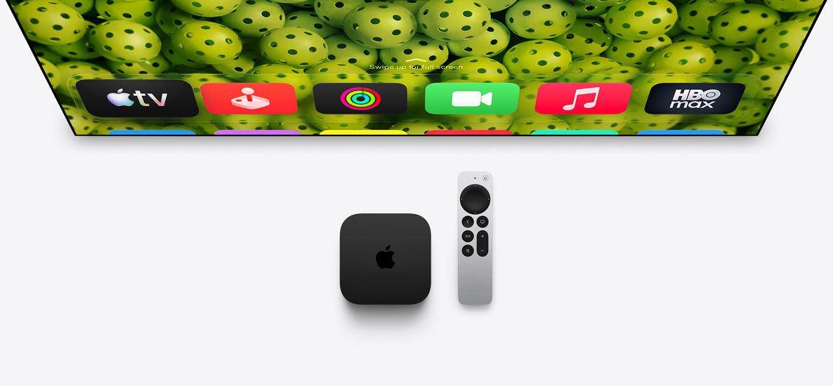 Apple TV 4K and Siri Remote below TV screen, screen shows Home Screen top row app icons over a green pickleballs background