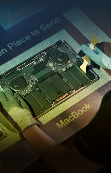 يدان بقفازات تفكّكان MacBook، وتظهر المكونات الداخلية