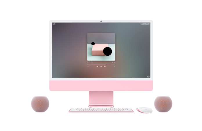 Lyserød iMac vist forfra med Apple Music, der afspilles på skærmen, Magic Keyboard og Magic Mouse i matchende farver, flankeret af to lyserøde HomePod mini 2-højttalere i et stereopar